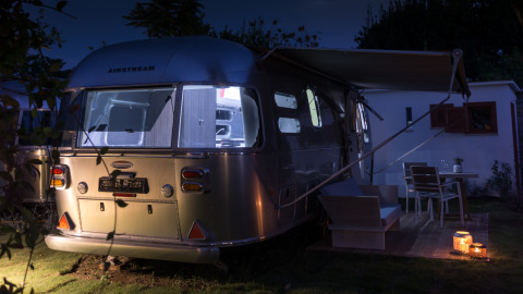 Hébergement glamping dans une luxueuse airstream au Procida Camp & Resort, éclairée de nuit à l'extérieur