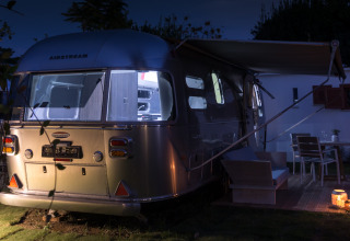 Hébergement glamping dans une luxueuse airstream au Procida Camp & Resort, éclairée de nuit à l'extérieur