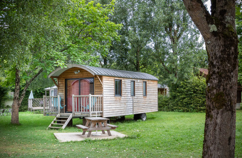 Alloggio glamping presso Huttopia La Plage Blanche, Franche-Comté, accogliente casetta in legno immersa nel verde.