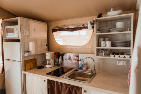 Cucina glamping moderna con lavello, fornelli, frigorifero e scaffali nelle Surf Tribe Lodges, Biscarrosse.