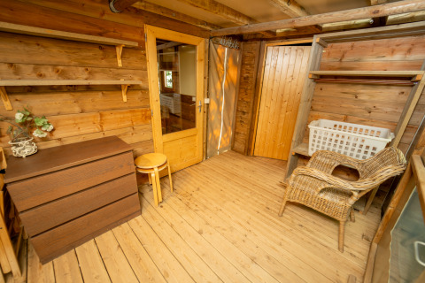 Interieur van een houten hut bij Vallicella Glamping Resort - Airdreamer Toscane met meubels en mand.