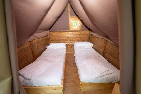 Interieur van een tentkamer met twee eenpersoonsbedden bij Vallicella Glamping Resort – Airdreamer Toscane.