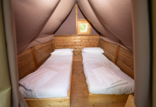 Interieur van een tentkamer met twee eenpersoonsbedden bij Vallicella Glamping Resort – Airdreamer Toscane.