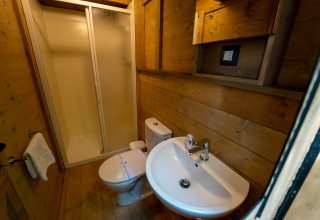 Moderne houten badkamer met douche, toilet en wastafel bij Vallicella Glamping Resort, Airdreamer Toscane.
