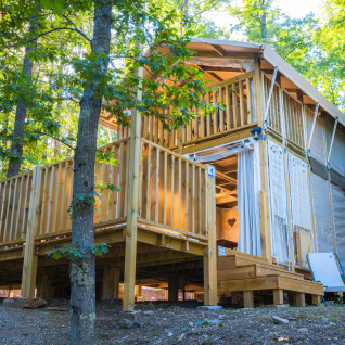 Tente glamping à deux étages avec terrasse en bois en forêt au Chianti Glamping Resort, Toscane, Italie.