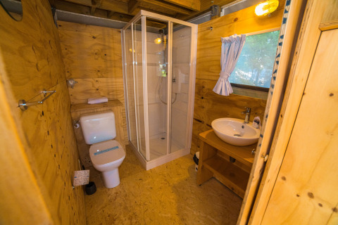 Moderne houten badkamer met douche, toilet en wastafel bij Chianti Glamping Resort Airlodges Toscane.