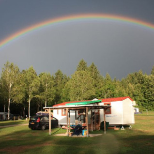 Glamping-Unterkunft Camping Rosental Rož - Stacarvans Karinthië mit Regenbogen über dem Campingplatz.