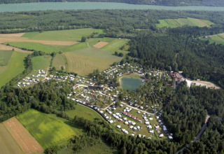 Luchtfoto van Camping Rosental Rož - Stacarvans Karinthië, omgeven door bos, velden en een meer.