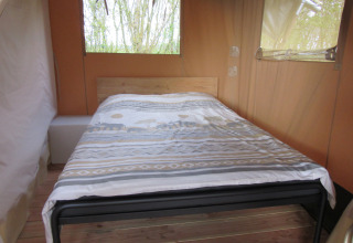 Vue intérieure d’un lit confortable dans une tente safari à Familiecamping Hendriks Wijkje - Safaritenten Drenthe.