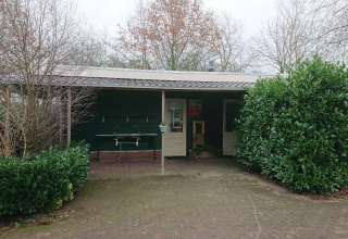 Udendørs faciliteter ved Familiecamping Hendriks Wijkje - Safaritenten Drenthe, omgivet af grønne buske.