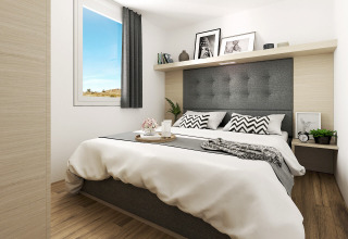 Lichte en moderne slaapkamer in Glamping Village Kötschach met tweepersoonsbed, raam en houten vloer.