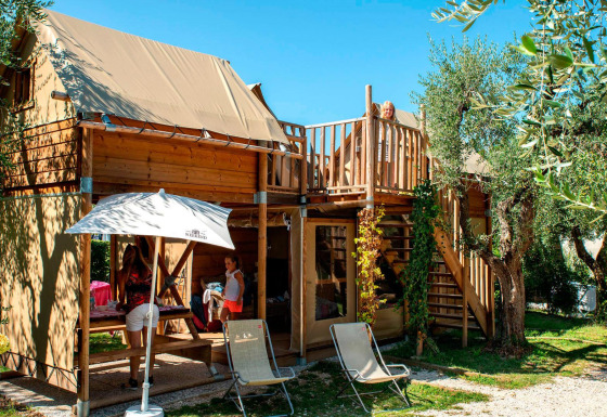 Glamping-Unterkunft bei Lago Idro Glamping Boutique in der Lombardei mit Familien, Bäumen und Terrasse.