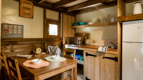 Cozy wooden kitchen and dining area at Lago Idro Glamping Boutique in Lombardy, Italy.