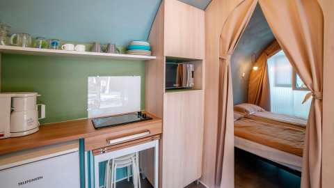 Sistemazione glamping moderna con piccola cucina e camera da letto al Lago Idro Glamping Boutique in Lombardia.