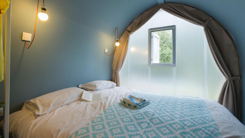 Sfeervolle glamping accommodatie bij Lago Idro Glamping Boutique in Lombardije met tweepersoonsbed en raam.