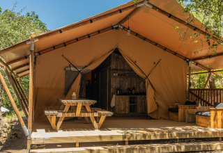 Hébergement glamping chic à Lago Idro Glamping Boutique avec terrasse en bois et tente de style safari.