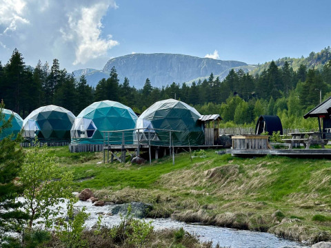 Cupole geodetiche per glamping a Brokkestøylen in Agder, immerse tra foresta, torrente e montagne nordiche.