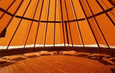 Interior of a glamping dome at Brokkestøylen - Domes in Agder, featuring wood floors and cozy seating areas.