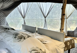Sistemazione glamping a Brokkestøylen - Domes in Agder con letto matrimoniale e ampie finestre panoramiche.