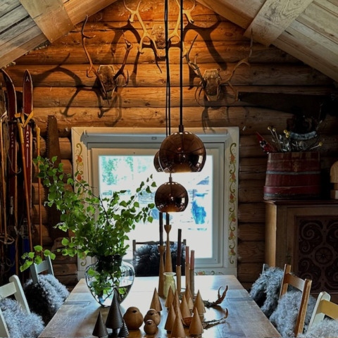 Intérieur chaleureux de cabane en rondins à Brokkestøylen - Domes in Agder, décoré de bois et de ramures.