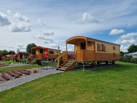 Sistemazioni glamping presso Campingplatz Auf dem Simpel - Pipowagen in Germania, con tavoli esterni.