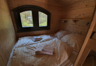 Hyggelig træhytte med dobbeltseng og vindue, glamping på Campingplatz Auf dem Simpel, Pipowagen Duitsland.