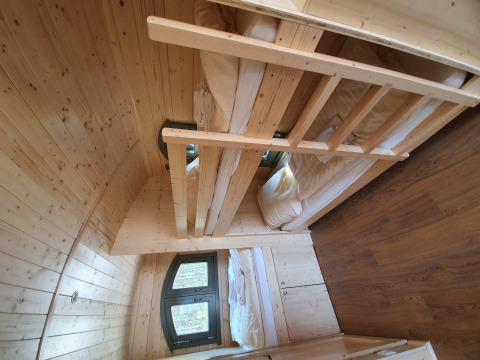 Interior of wooden glamping hut with bunk beds and window at Campingplatz Auf dem Simpel - Pipowagen Duitsland.