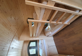 Innenraum einer Holzhütte mit Etagenbetten und Fenster, Campingplatz Auf dem Simpel - Pipowagen Deutschland.