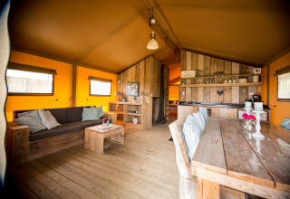 Innenraum der Glamping-Unterkunft Villa la Diva - Safaritenten Le Marche mit rustikalen Holzmöbeln.