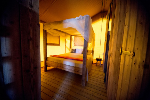 Glamping Unterkunft, Villa la Diva - Safarizelte Le Marche, gemütliches Schlafzimmer mit Holzmöbeln.