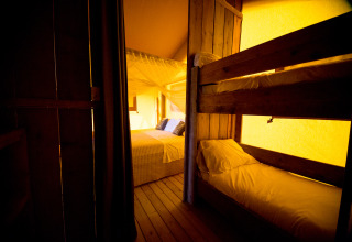 Interno glamping Villa la Diva - Safaritenten Le Marche con letto matrimoniale e letto a castello in legno.