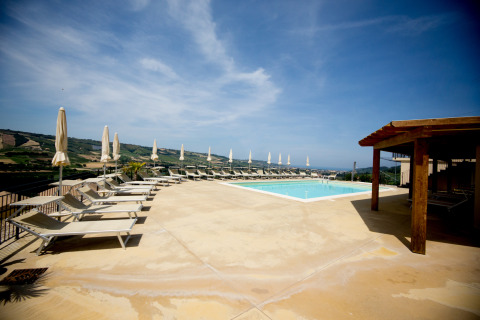 Espace piscine extérieure avec transats et parasols à Villa la Diva - Safaritenten Le Marche, glamping en Italie.