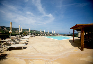 Außenpool mit Liegestühlen und Sonnenschirmen bei Villa la Diva - Safaritenten Le Marche, Glamping Italien.