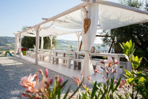 Udendørs spiseområde ved Villa la Diva - Safaritenten Le Marche glamping med udsigt over bakker.