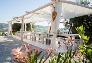 Udendørs spiseområde ved Villa la Diva - Safaritenten Le Marche glamping med udsigt over bakker.