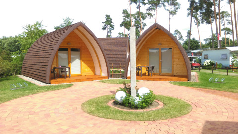 Glampingindkvartering hos Campingpark Buntspecht i Brandenburg med moderne træhytter og udendørs terrasse.