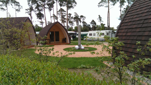 Hébergement glamping au Campingpark Buntspecht - Pods Brandenburg avec pods, verdure et caravanes à proximité.