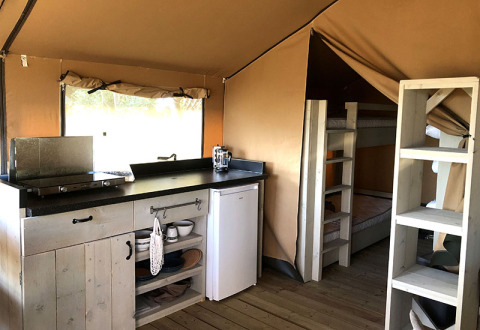 Interior view of a glamping tent with kitchenette and bunk beds at Camping Groß-Eichen - Safaritenten Hessen.