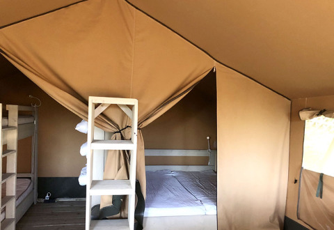 Interno di una tenda safari al Camping Groß-Eichen con letto matrimoniale e letti a castello in Assia.