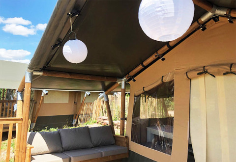 Luksustelt med sofa og lanterner på Camping Groß-Eichen - Safaritenten Hessen under blå himmel.
