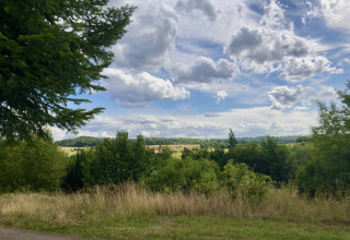 Vista sulla campagna lussureggiante vicino a Camping Groß-Eichen - Safaritenten Hessen sotto cielo nuvoloso.