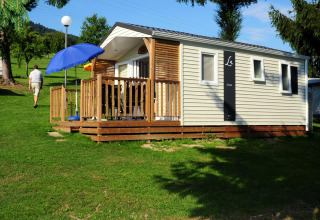 Alloggio glamping moderno al Camping Schwarzwaldhorn con terrazza in legno e ombrellone in Baden-Württemberg.