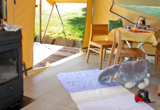 Interior de tienda glamping en Camping Schwarzwaldhorn con elefante de peluche y muebles de madera, Baden-Württemberg.
