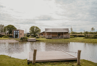 Glamping accommodatie aan een vijver bij De Betuwse Hofjes - Betuwe Lodges Gelderland, met moderne lodges.