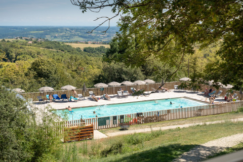 View of the swimming pool area with loungers and umbrellas at Village Huttopia Pays de Condrieu, Auvergne-Rhône-Alpes.