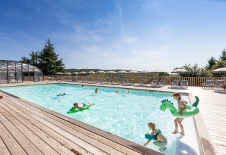 Kinder spielen im Außenpool des Village Huttopia Pays de Condrieu Glampings in Auvergne-Rhône-Alpes.