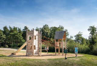 Niños jugando en el parque infantil de Village Huttopia Pays de Condrieu, Glamping Auvergne-Rhône-Alpes.