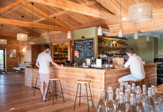 Réception et bar en bois au Village Huttopia Pays de Condrieu Glamping, Auvergne-Rhône-Alpes, France.