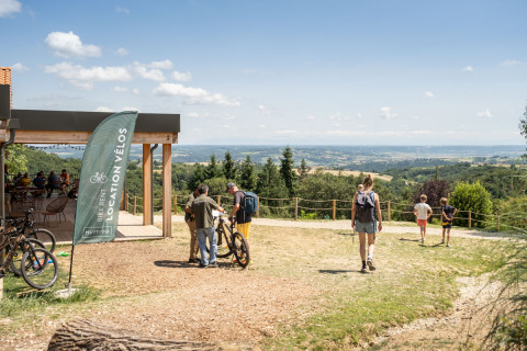 Vista panoramica al glamping Village Huttopia Pays de Condrieu con noleggio bici e ospiti presenti.