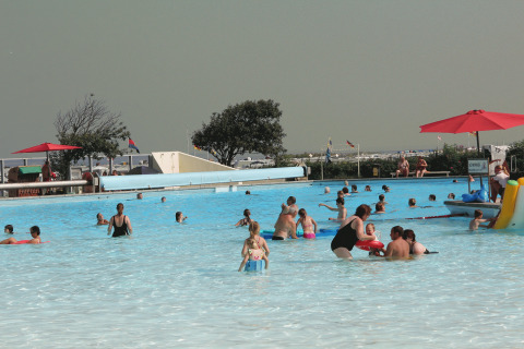 Familien entspannen und spielen im Schwimmbad des Campingplatz am Nordseestrand, Oost-Friesland.
